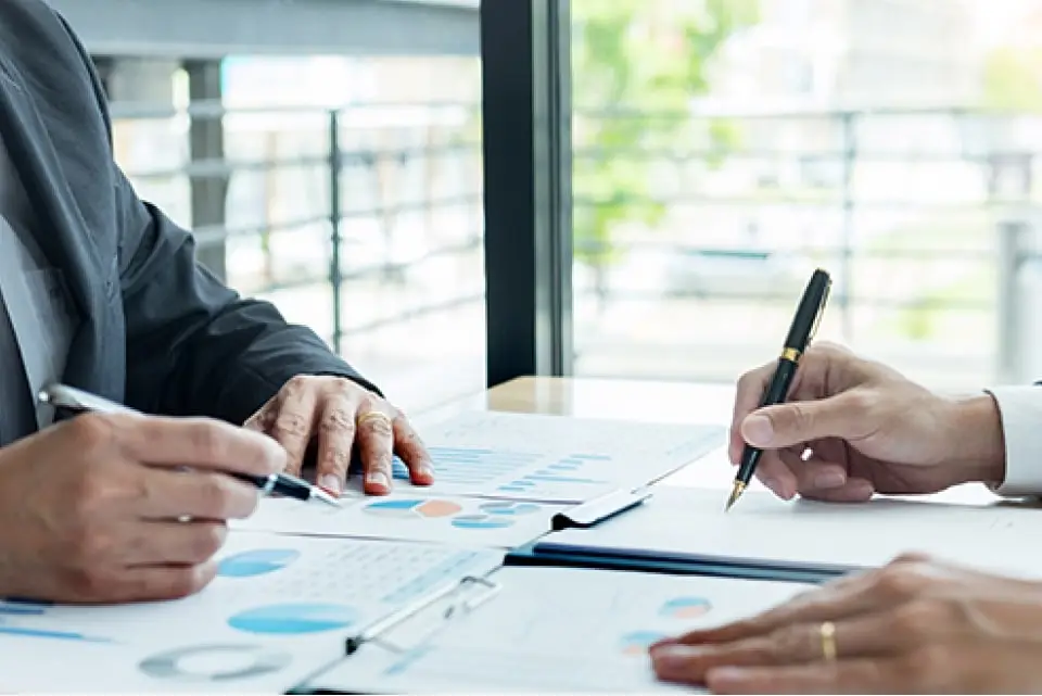 手元の資料を見ながらメモをとりながら打合せをしている様子