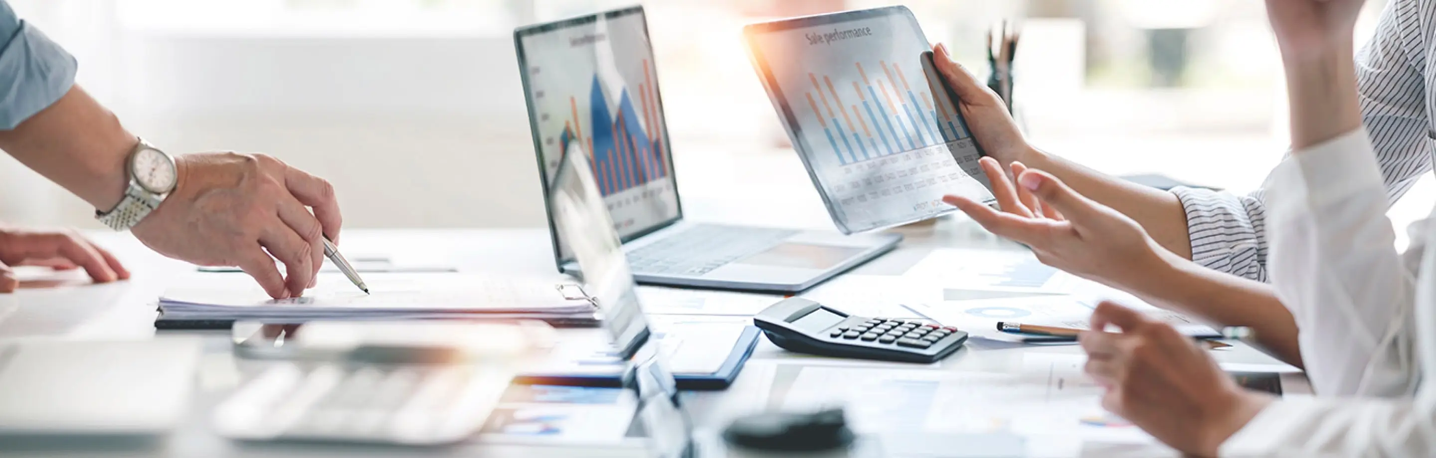 資料、PC、タブレット端末を見ながら打合せをしている様子