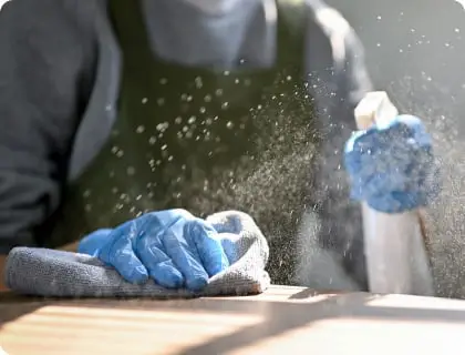 スプレーをテーブルに吹きかけて掃除をしている様子